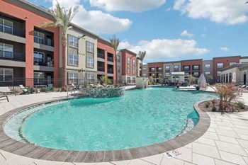 A swimming pool with an apartment building in the background
